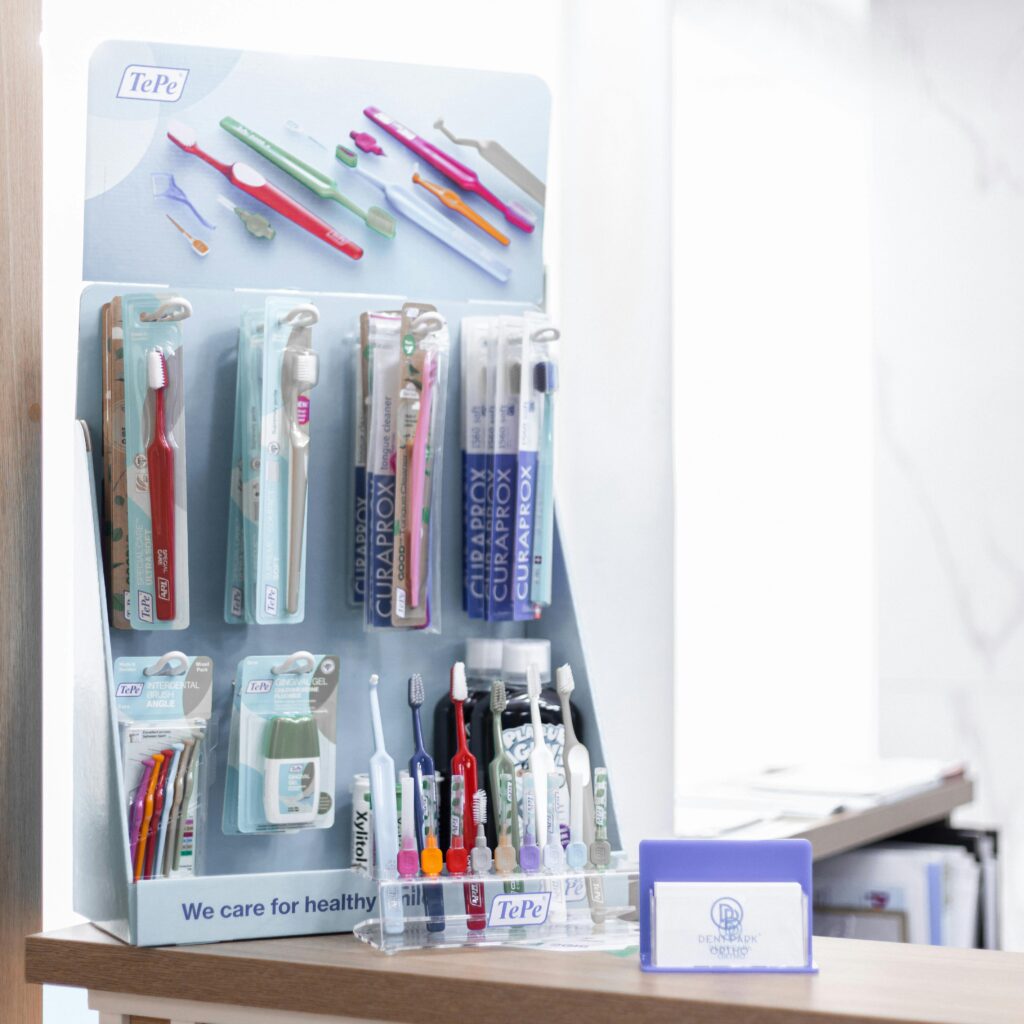Assorted toothbrushes on a display stand in a dental clinic setting, emphasizing oral health.